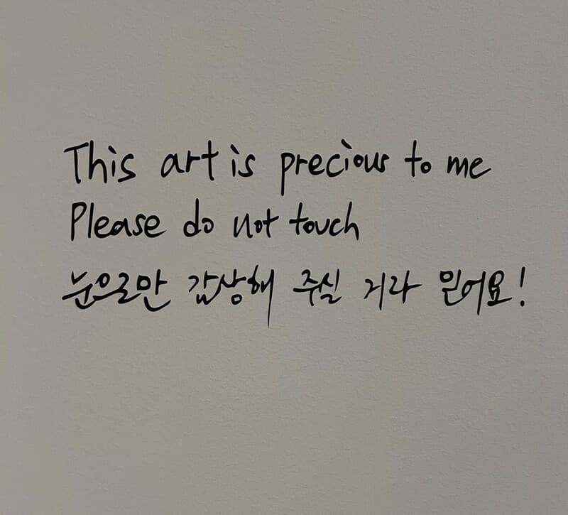 Kim Namjoon's handwritten signs and labels in English and Korean adorn the exhibit. 