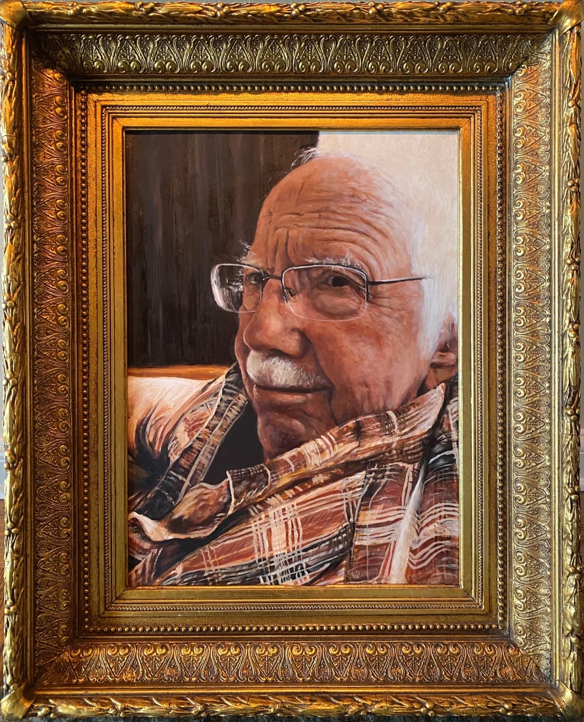 Worth, Andrew Conru’s portrait of his father: an older man with white hair and glasses, in a plaid shirt, in an ornate gold frame.